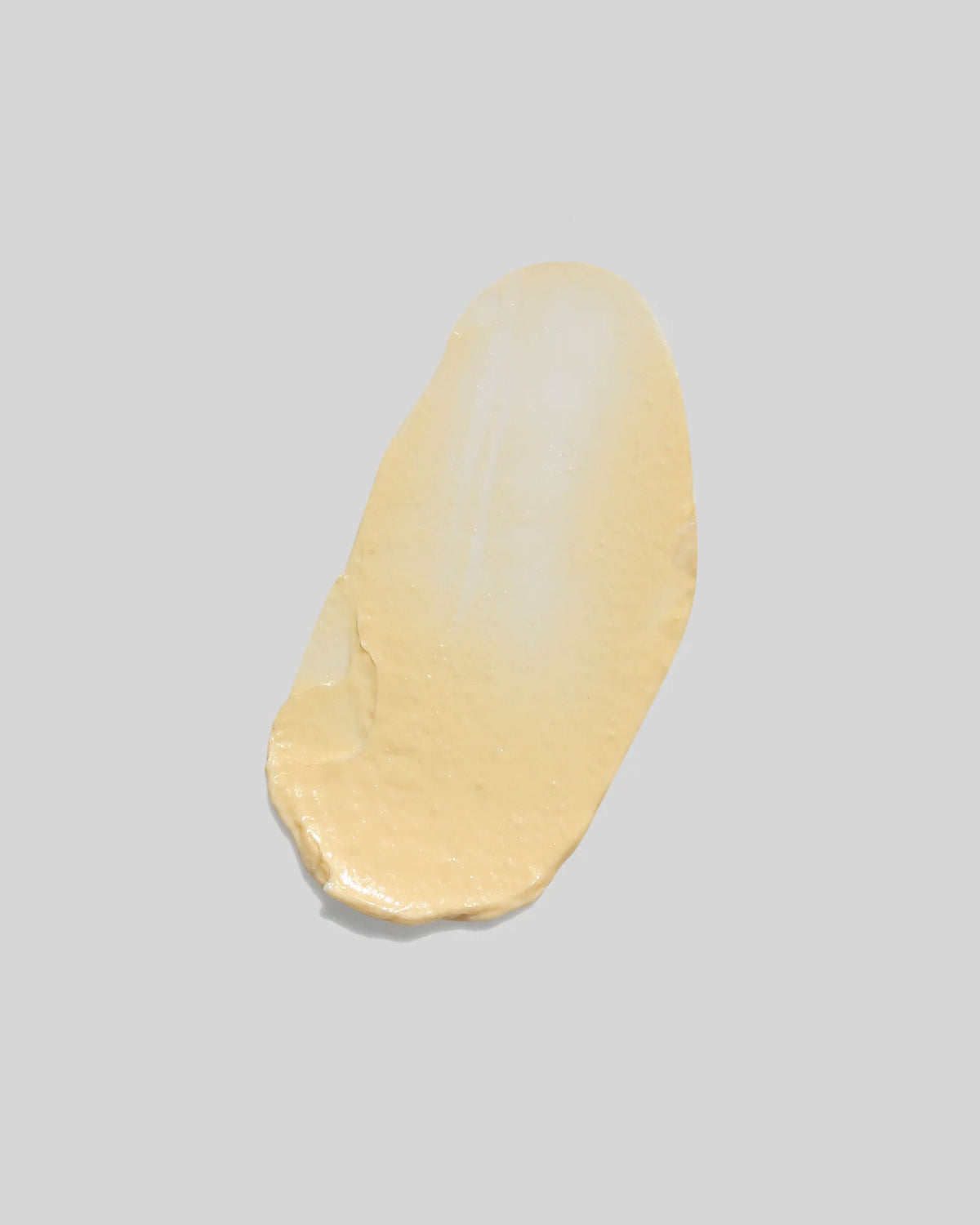 A butter-coloured smear of cream on an off-white background.