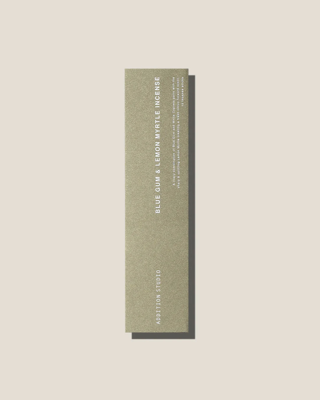 An olive-green long, slim rectangular cardboard package with white type which reads Addition Studio BLUE GUM &amp; LEMON MYRTLE INCENSE, set on an off-white background.