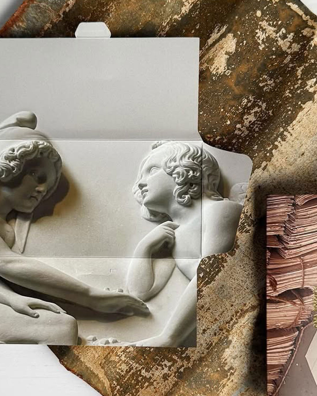 The inside packaging of a Casa Bosques chocolate bar. A cardboard package with an image of a marble statue.