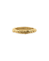 A gold band ring with circle embellishments running in a single row along the ring. Inside back of ring reads the brand&