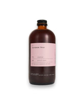 An amber glass bottle labelled Cardamom Rose on white background.