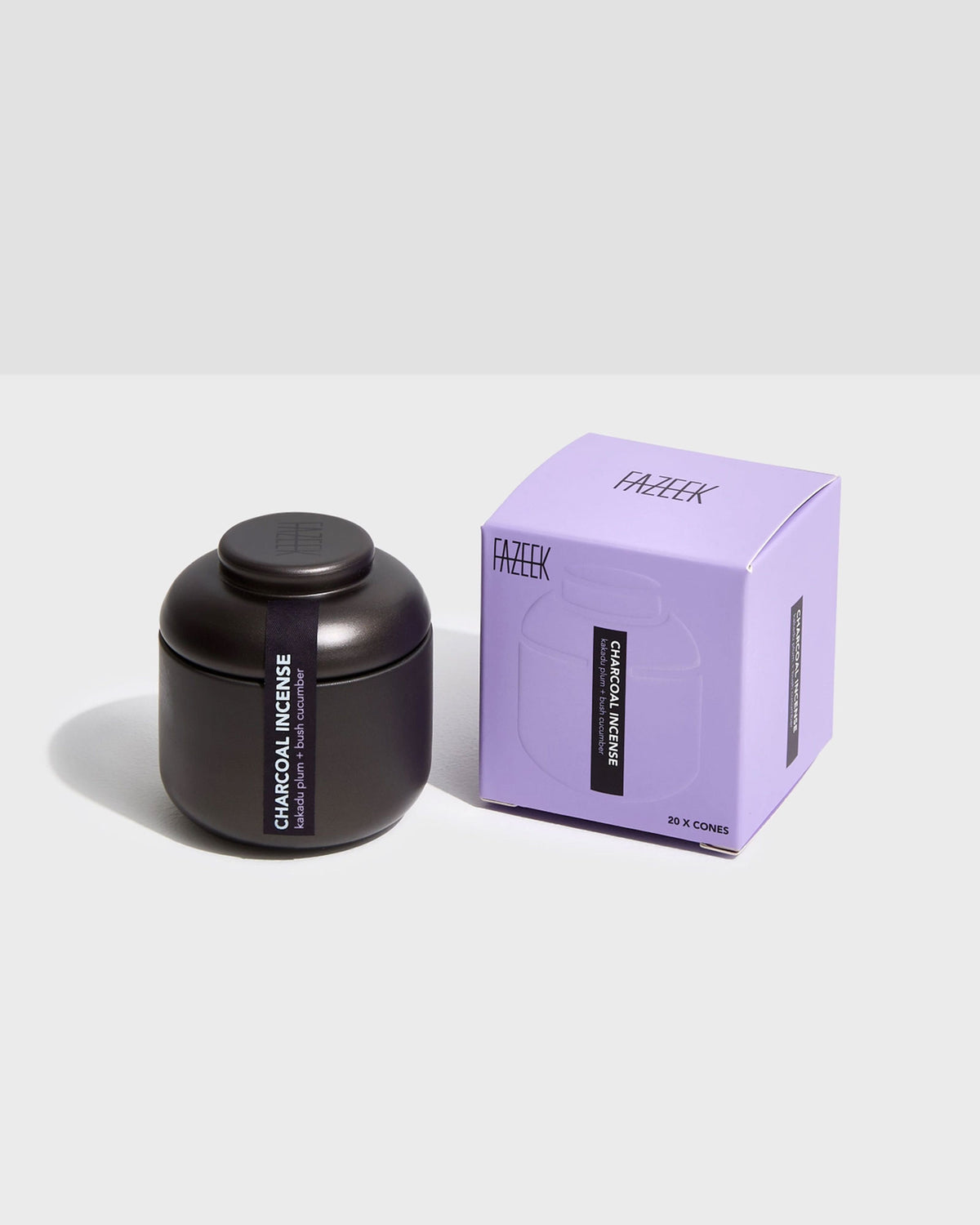 Product shot showing a charcoal-coloured tin canister alongside its cardboard box packaging. Both the tin canister and purple box are labelled "CHARCOAL INCENSE kakadu plum and bush cucumber".