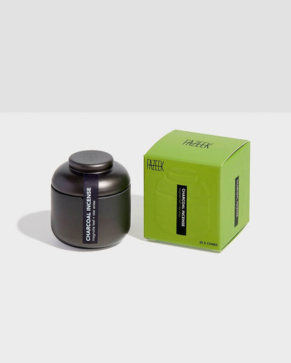 Product shot showing a charcoal-coloured tin canister alongside its cardboard box packaging. Both the tin canister and green box are labelled "CHARCOAL INCENSE magnolia leaf and star anise".