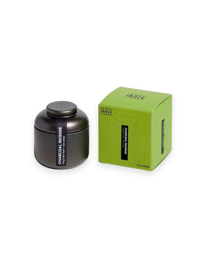 Product shot showing a charcoal-coloured tin canister alongside its cardboard box packaging. Both the tin canister and green box are labelled "CHARCOAL INCENSE magnolia leaf and star anise".