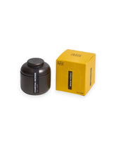 Product shot showing a charcoal-coloured tin canister alongside its cardboard box packaging. Both the tin canister and light yellow box are labelled "CHARCOAL INCENSE teak and neroli".