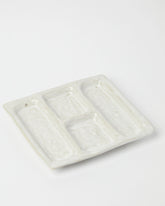 Product shot of a white ceramic platter designed with 4 recessed compartments.