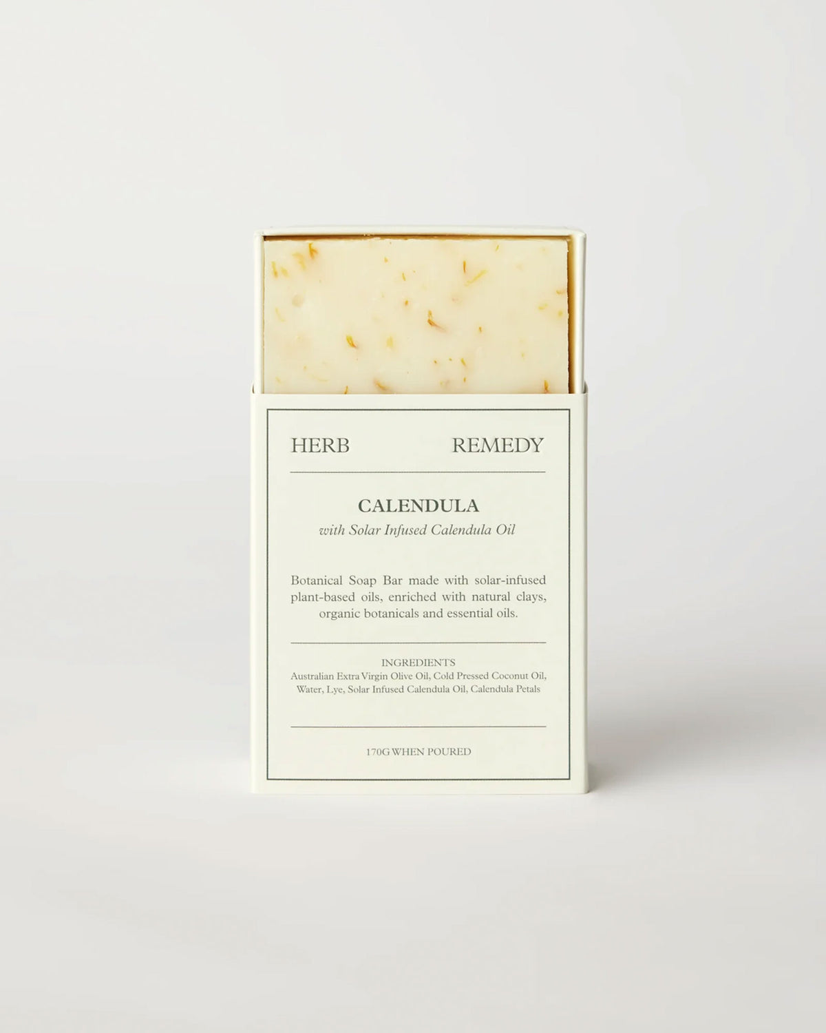 Herb Remedy Calendula botanical soap bar in a white paper sleeve packaging, showing the textured off-white soap bar with small specks at the top, on a clean white background.