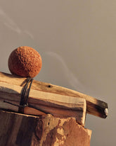 A bundle of 2 small wood pieces, one is gently smouldering. 