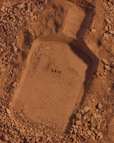 The signature shape of the Leif bottle impressed into brown earth.