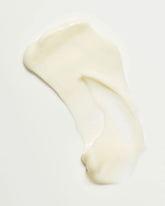 A dollop of thick, creamy off-white body lotion on a plain white background.