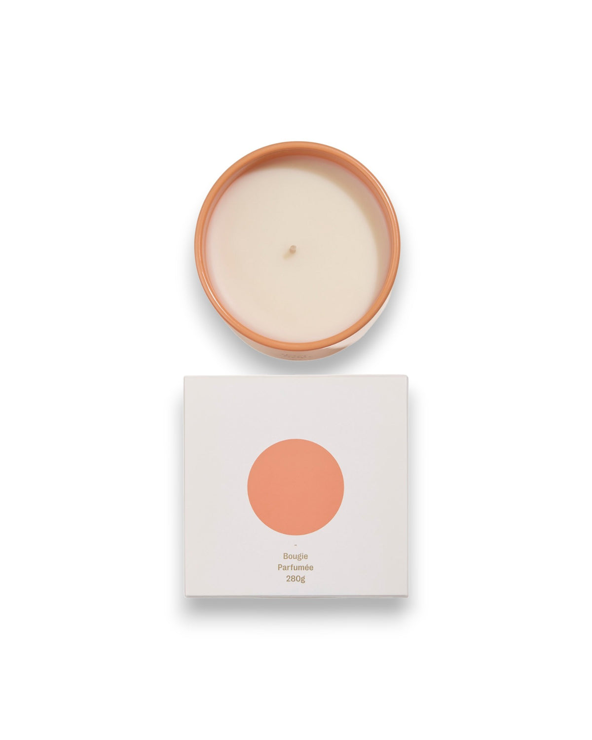 Birdseye view of a round unlit candle next to its square box that features a white lid with a peach coloured circle corresponding to the same colour of the candle container. The box reads Bougie Perfumee 280g, set on an all white background.