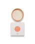Birdseye view of a round unlit candle next to its square box that features a white lid with a peach coloured circle corresponding to the same colour of the candle container. The box reads Bougie Perfumee 280g, set on an all white background.