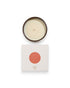 Birdseye view of a round unlit candle next to its square box that features a white lid with an orange coloured circle. The box reads Bougie Perfumee 280g, set on an all white background.