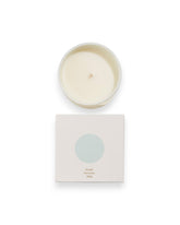 Birdseye view of a round unlit candle next to its square box that features a white lid with a baby blue coloured circle. The box reads Bougie Perfumee 280g, set on an all white background.