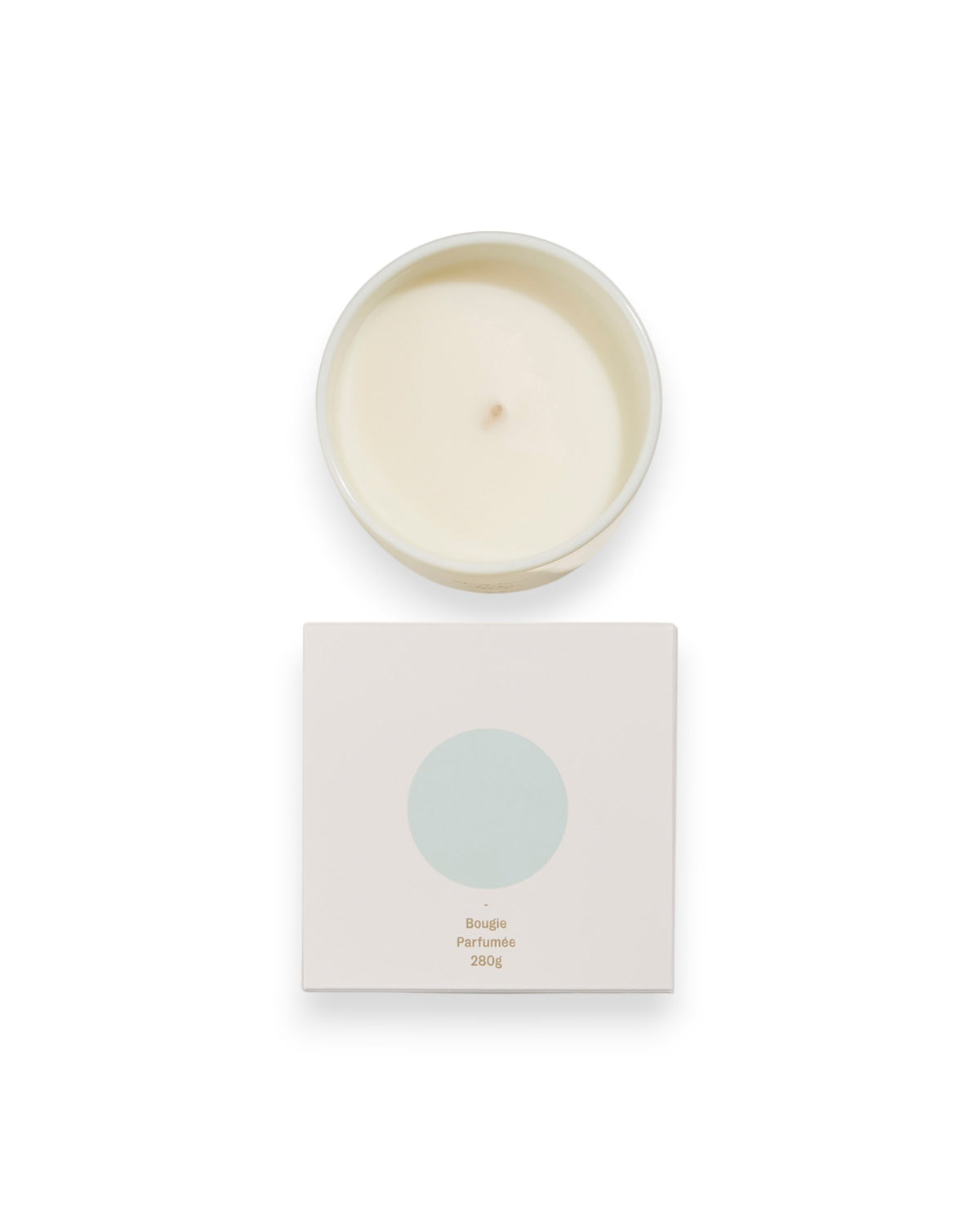 Birdseye view of a round unlit candle next to its square box that features a white lid with a baby blue coloured circle. The box reads Bougie Perfumee 280g, set on an all white background.