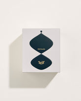 A square white box with a black abstract pattern with gold foil lettering which reads Wild Rosella Leif. Set on a white background.