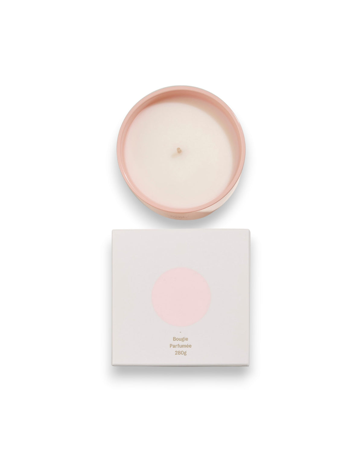 Birdseye view of a round unlit candle next to its square box that features a white lid with a baby-pink coloured circle corresponding to the same colour of the candle container. The box reads Bougie Perfumee 280g, set on an all white background.