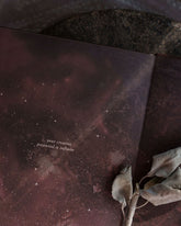 An open book with a dark purple starry night background and centred text that reads "...your creative potential is infinite". A sprig of dried white sage is placed in the fold of the open book. 