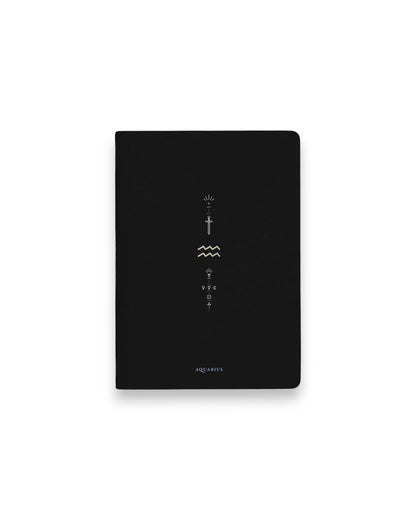 A black hardcover notebook featuring the Aquarius zodiac sign and its chart symbols printed in metallic on the front cover, set against a clean white background.