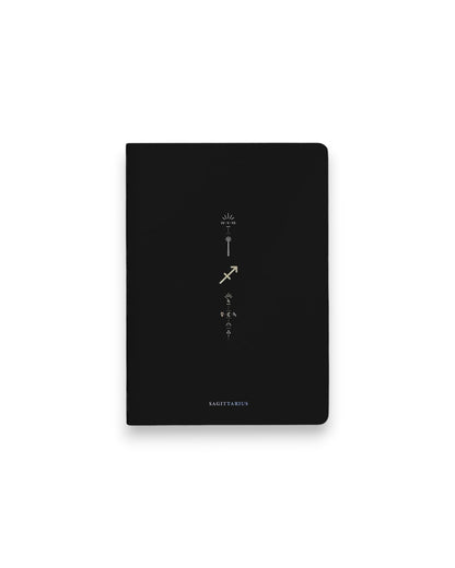 A black hardcover notebook featuring the Sagittarius zodiac sign and its chart symbols printed in metallic on the front cover, set against a clean white background.
