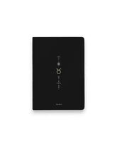 A black hardcover notebook featuring the Taurus zodiac sign and its chart symbols printed in metallic on the front cover, set against a clean white background.