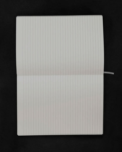 An open lined notebook with blank white pages, photographed from above against a solid black background.