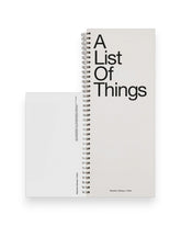 A tall ledger style notebook with wire binding, cover reads in large black letters A List Of Things. Set on a solid white background.