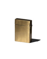 A rectangular brass card case with a brushed satin finish on a light grey background. 