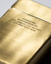 A rectangular brass card case with a brushed satin finish and etched wording on the front.