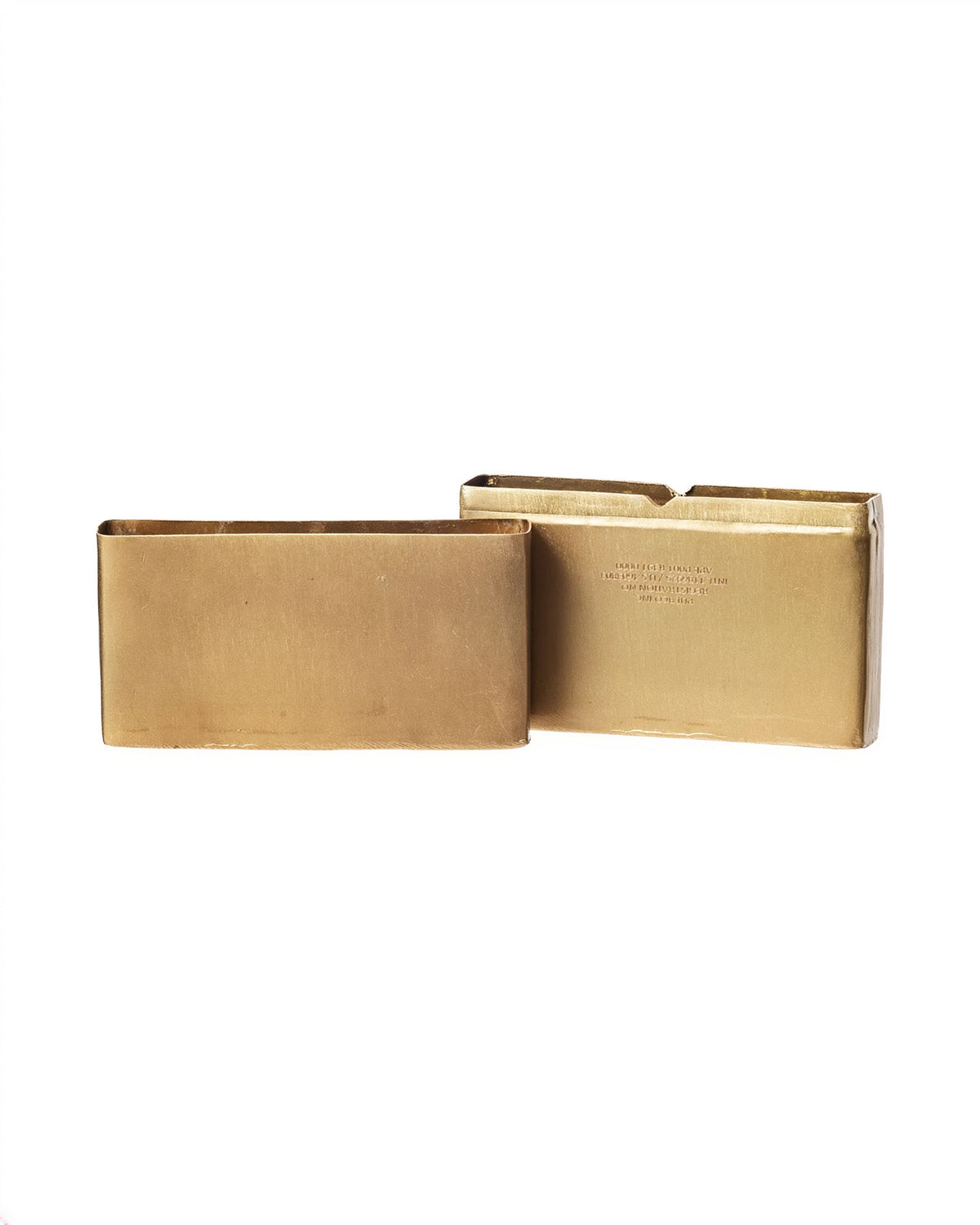 Two brass metal empty box halves on a white background.