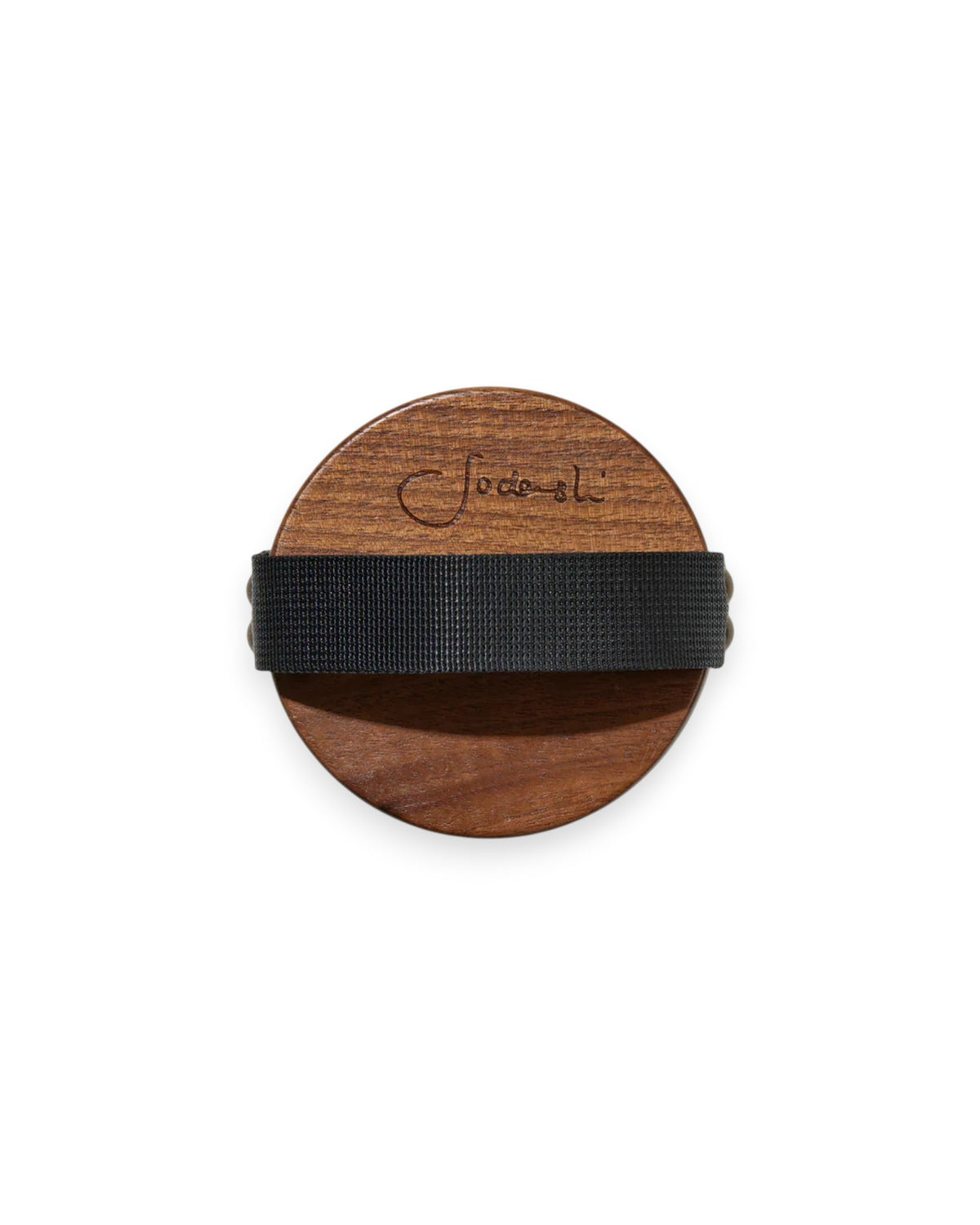 The back of a Sodashi Dry Body Brush showing the Sodashi logo, a black elastic backstrap and the dark stained wood. The brush is a perfect circle. White background.