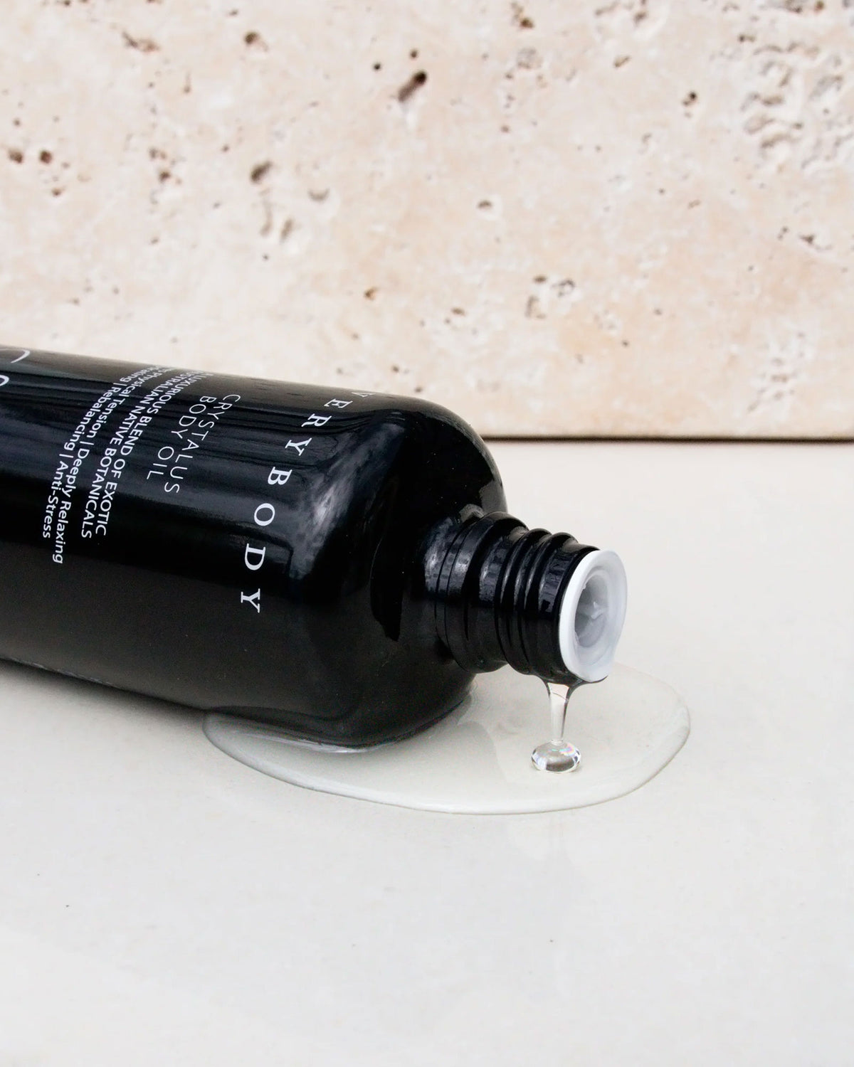 A black, cylindrical, glass bottle of Sodashis&