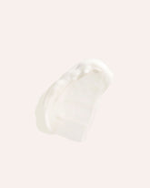 A smear of white cream on an off-white background.