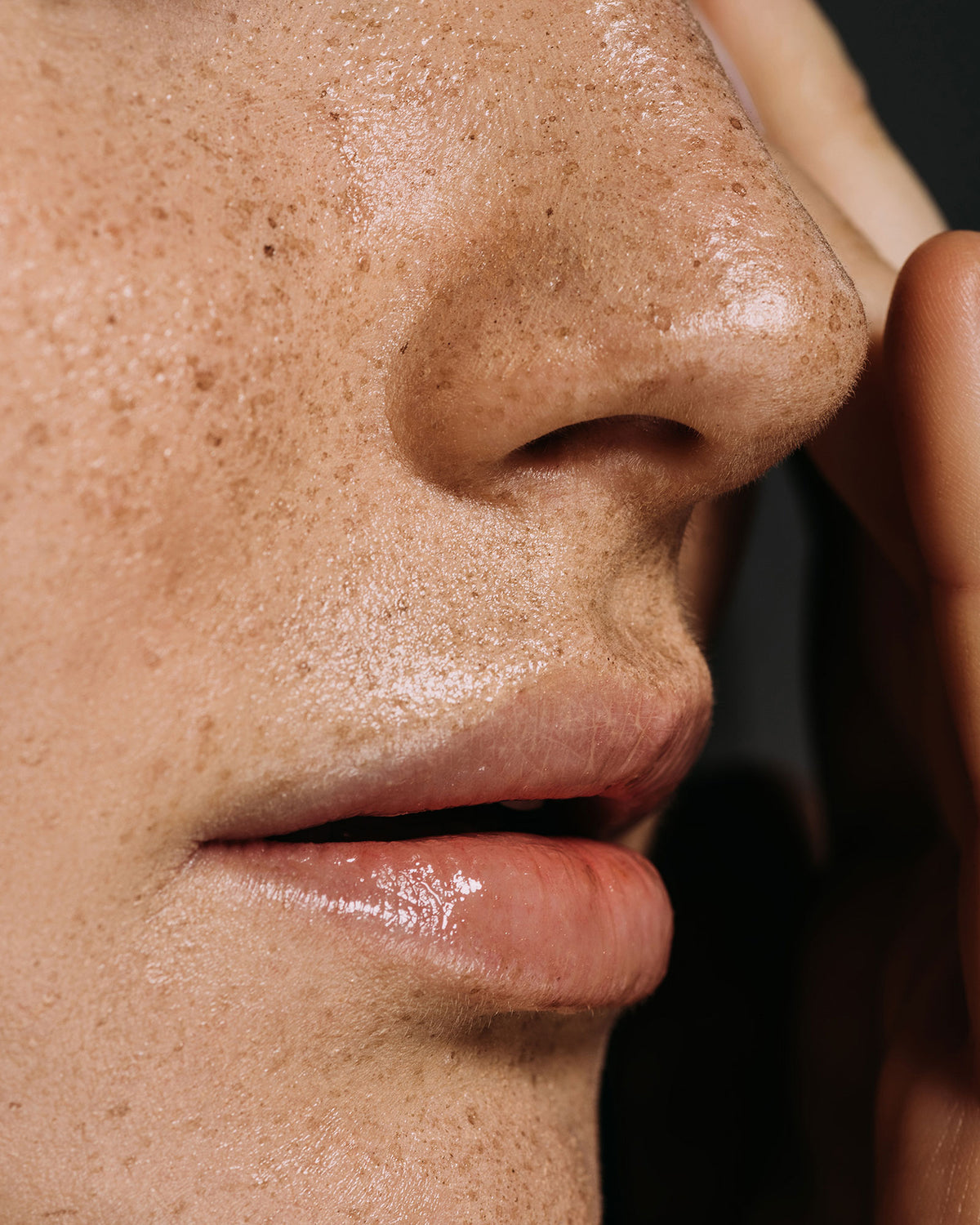 Close-up of a woman touching her face.