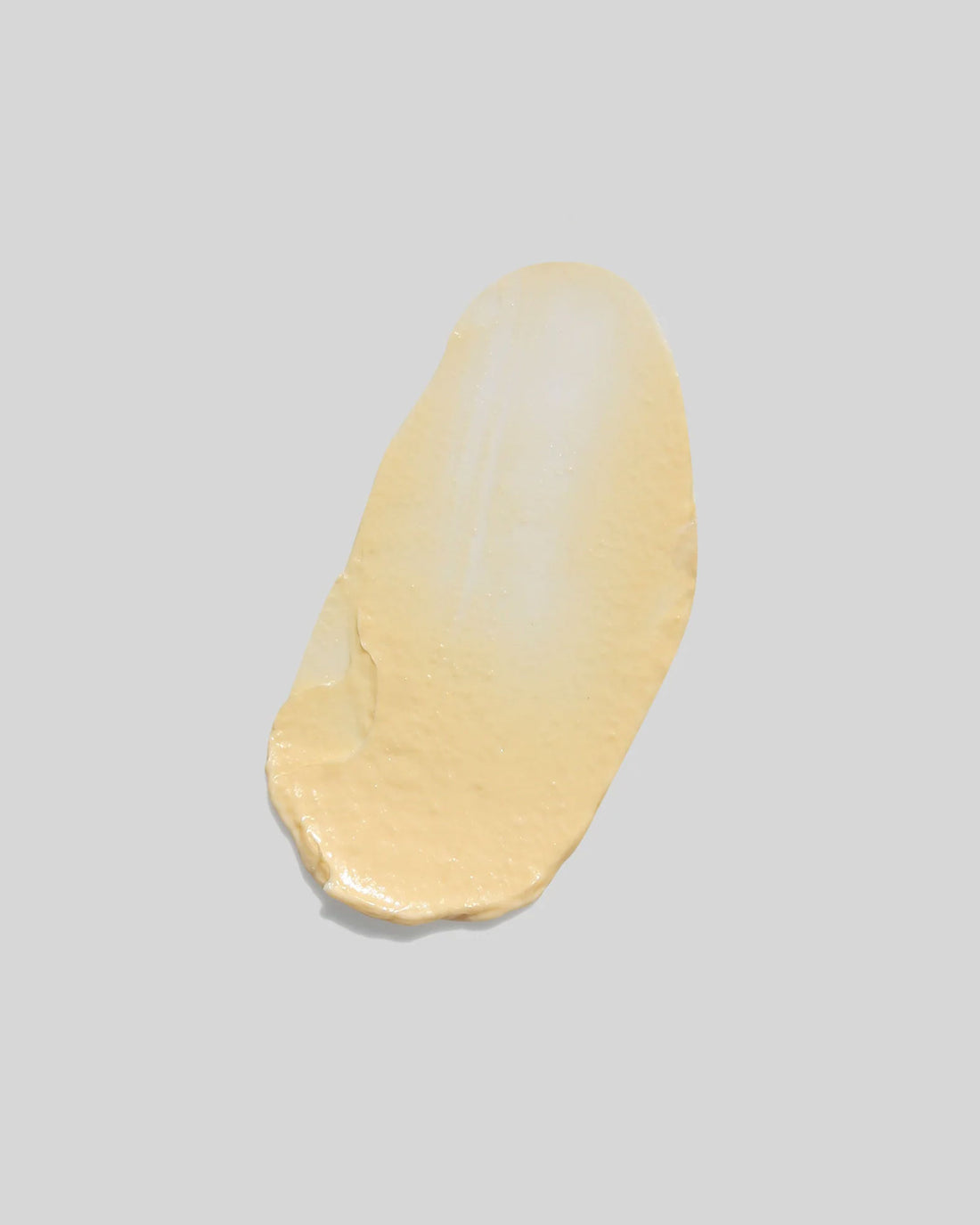 A butter-coloured smear of cream on an off-white background.