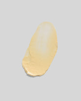 A butter-coloured smear of cream on an off-white background.