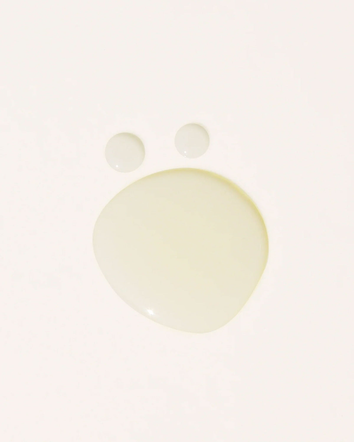 Transparent oil droplets on an off-white background.