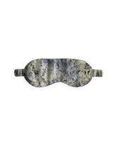 A silk eye mask with a marbled pattern in cream, beige, and dark purple, shown against a plain white background.