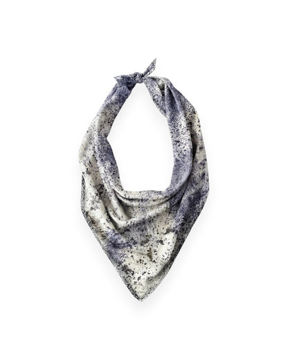 A blue and cream mottled silk scarf tied as a traditional neck scarf on solid white background.