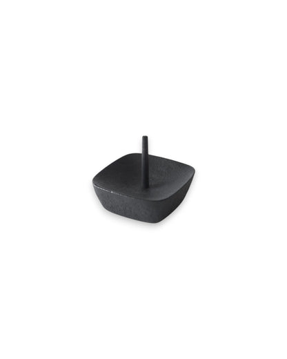 Product shot of a black iron candle stand with a square design and a central pin.