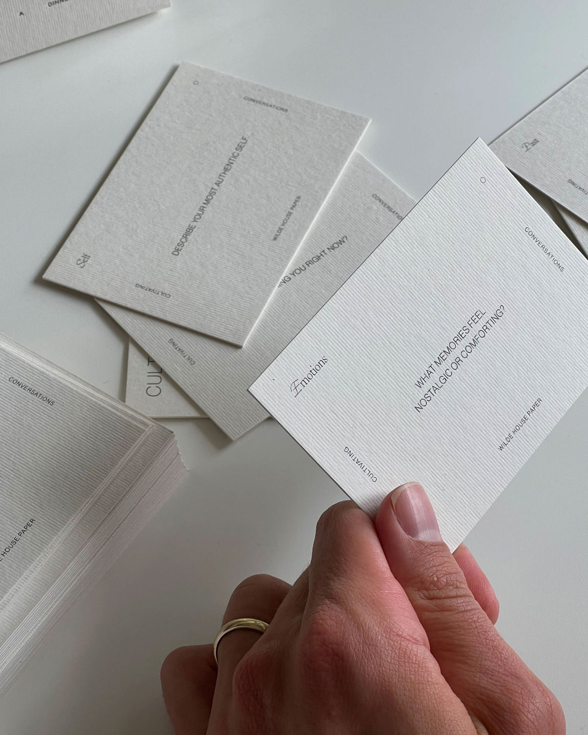 A hand holding one Wilde House Paper&
